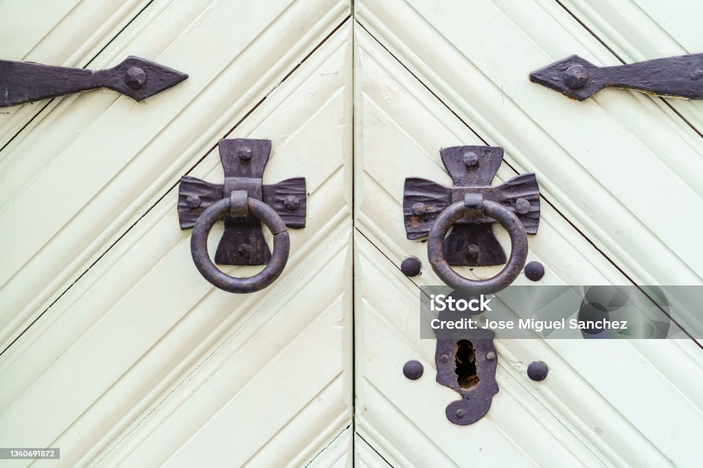 White wooden door with lock and black metal hardware. Ancient Stock Photo