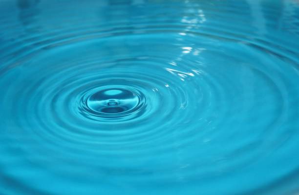 istock water drop splash background blue, water ripple and antibubble drop - water surface tension 1340693506