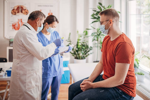 istock Senior doctor is checking patient's temperature while nurse is taking notes in medical chart in Covid-19 clinic 1340694433