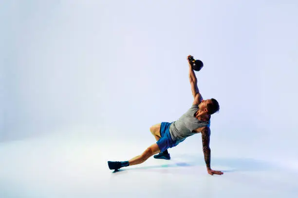 Photo of Strong young man exercising with kettle bell