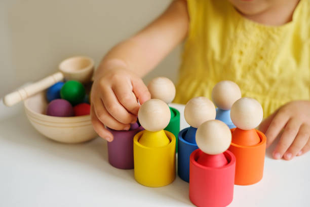 A modern toy sorter made of wood, for studying flowers by preschoolers A modern creative toy sorter made of wood, for studying flowers by preschoolers. Figurines in the form of little men in cups montessori education photos stock pictures, royalty-free photos & images