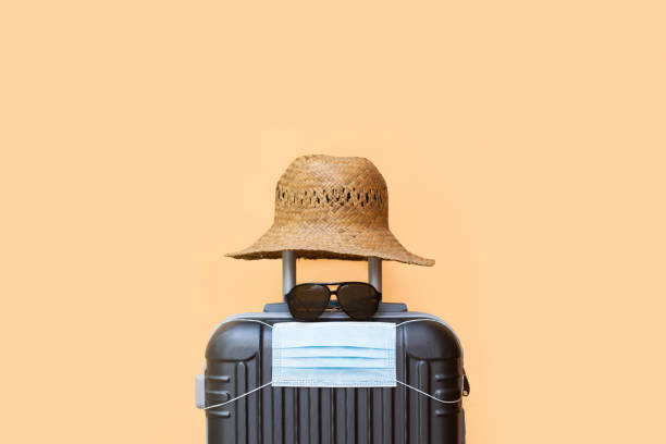 istock A suitcase with a hat, sunglasses and surgical mask 1340698461