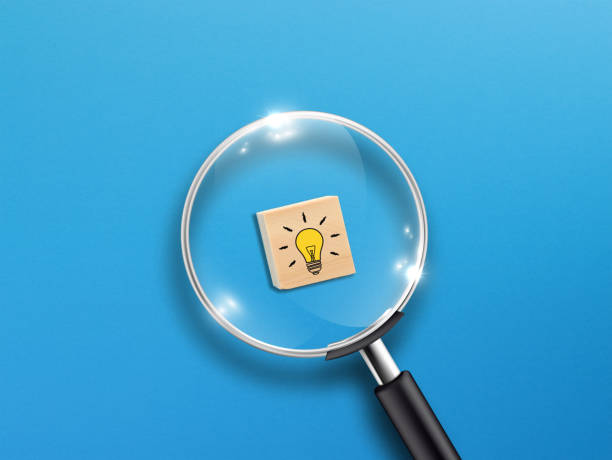 istock Creative idea concept, magnifying glass and light bulb icon on wooden block with blue background 1340700488