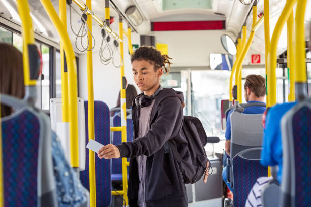 garçon payant le tarif par carte à puce dans le bus - farnes photos et images de collection