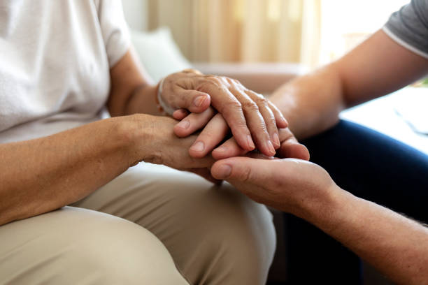 I'm always here for you. Cropped shot of an unrecognizable male nurse holding his senior patient's hand in comfort. Mother and son hands holding together in love and support after losing loved ones amid coronavirus outbreak. widow stock pictures, royalty-free photos & images