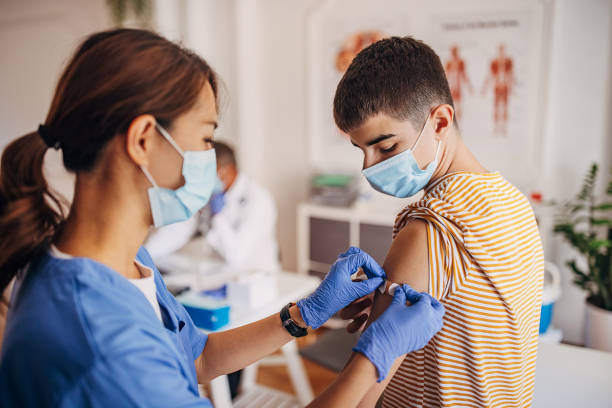 enfermeira coloca band aid no braço do paciente após vacinação covid-19 - caderneta de vacinação - fotografias e filmes do acervo