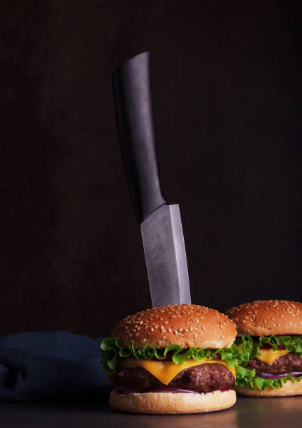 istock Delicious juicy burger with knife on dark background 1340701861