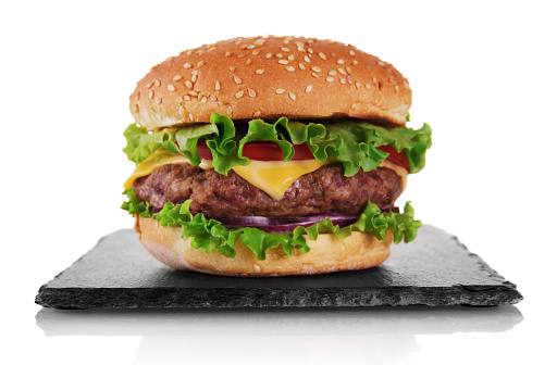 Appetizing burger with cutlet on slate board isolated on white background