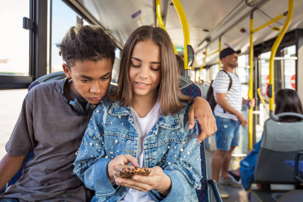 승객 버스에서 스마트 폰과 십대 커플 - bus commuter passenger mobile phone 뉴스 사진 이미지