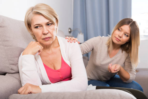 daughter comforts a sad mother An adult good daughter comforts her sad elderly mother mother in law stock pictures, royalty-free photos & images