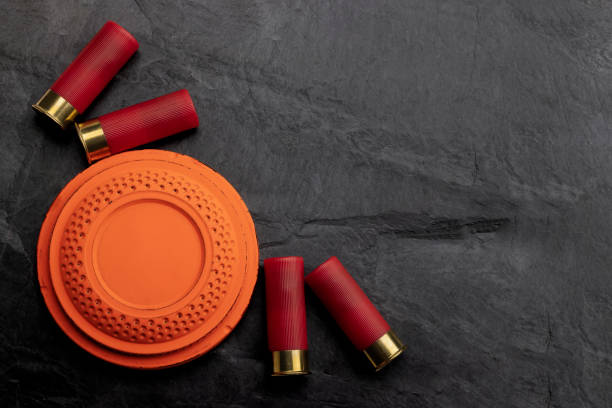 istock Clay shooting target with shotgun shell on black slate background , Shotgun game 1340707721