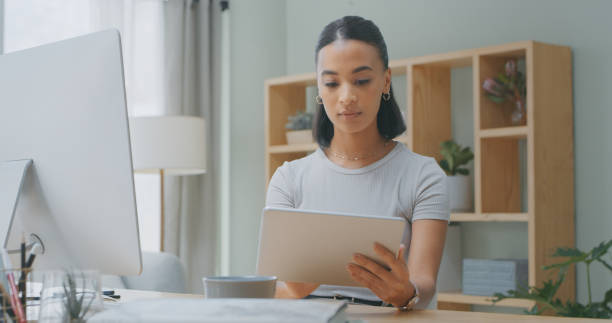 istock Shot of a young woman using a digital tablet while working from home 1340709057