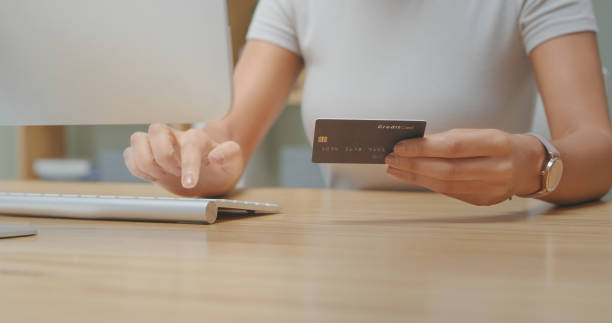 istock Shot of an unrecognizable person holding a credit card while using a computer at home 1340709082