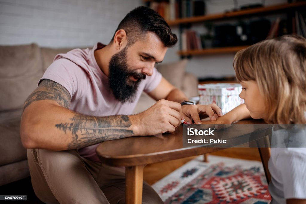 Father painting nails to his little girl Father painting nails to his little girl at home Single Father Stock Photo