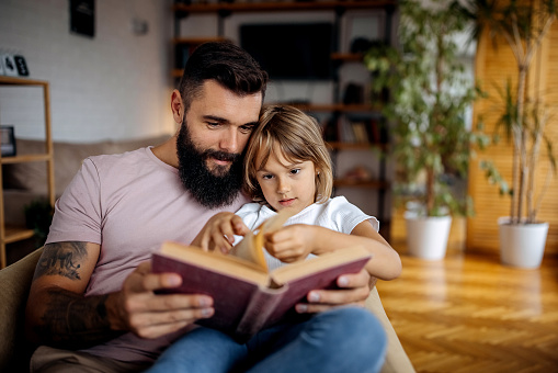 Father and daughter reading book together