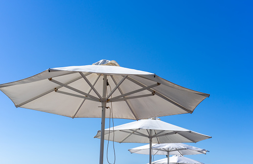 Many white beach umbrellas under the blue sky