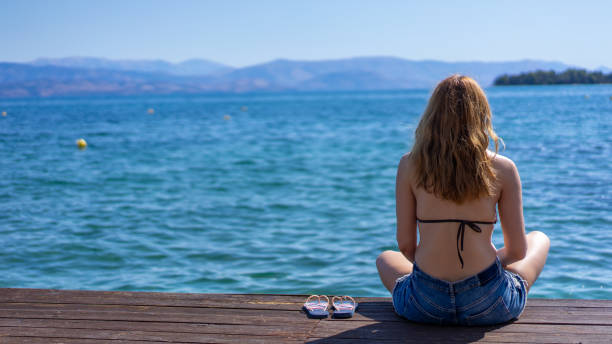 istock A young woman sitting on the beach 1340710788