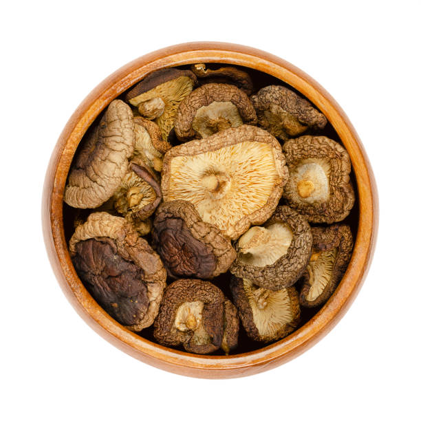 сушеные грибы шиитаке, lentinula edodes, в деревянной миске - shiitake mushroom edible mushroom mushroom dry стоковые фото и изображения
