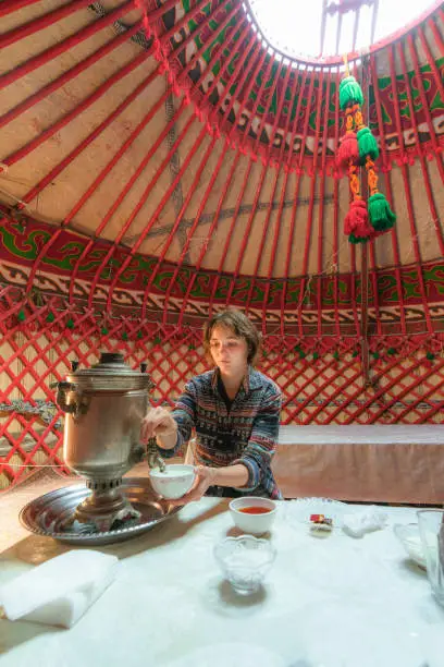 Young Caucasian woman drinking tea in yurt