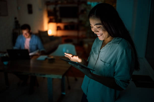 istock Happy woman using digital tablet late night 1340713536