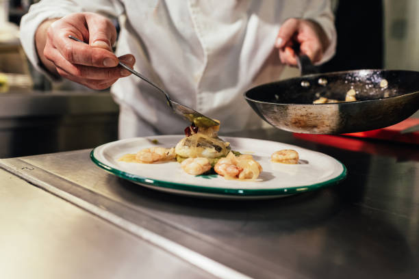 istock Male chef finishing a gourmet dish while working in a restaurant kitchen. 1340714206