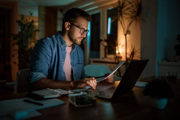 istock Serious handsome man working late from his home office 1340715393