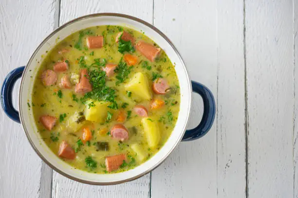 Photo of Pot with potato soup and vienna sausage