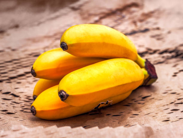 istock Bunch of mini bananas on craft paper 1340717617