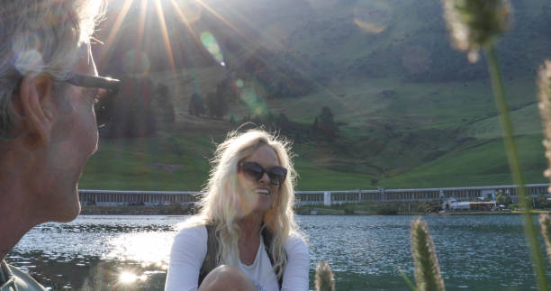 istock Couple pause by lake edge in conversation, mountains 1340718837