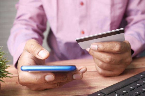 istock Man hand holding credit card and using smart phone shopping online 1340719156