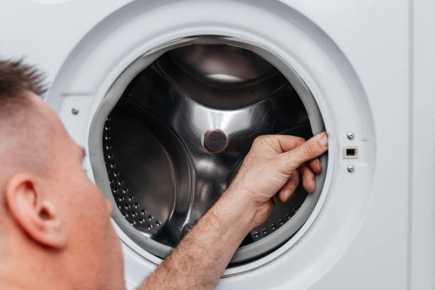istock Handyman repairing a washing machine. 1340719461