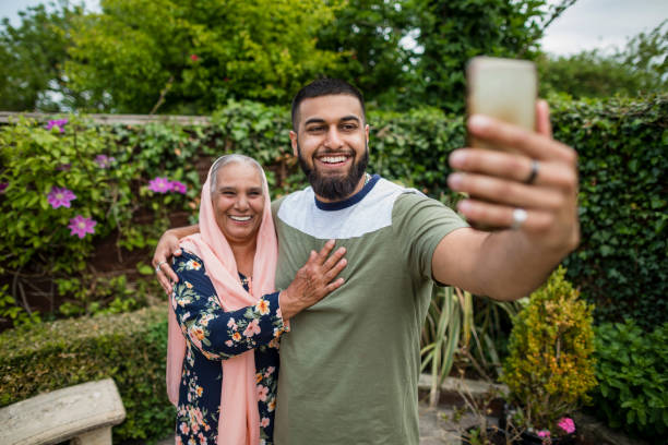 Selfie with Grandma Pakistani grandson and grandmother taking a selfie together in a garden in Middlesbourgh, North East of England. pakistani ethnicity stock pictures, royalty-free photos & images