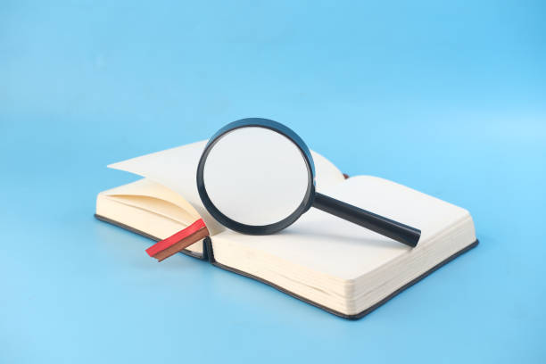 istock open book and magnifying glass on blue background . 1340720627
