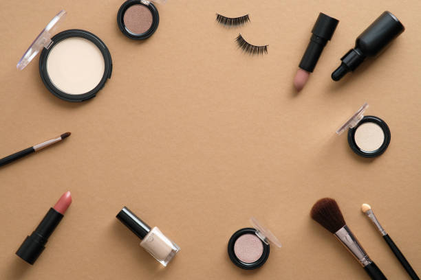 istock Frame made of makeup professional cosmetics on brown background. Flat lay, top view. 1340720706