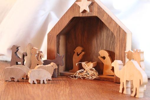 wooden figures and a manger scene in a rustic wood christmas holiday nativity decoration