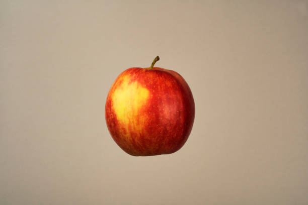 istock Fresh Red and Yellow Apple on Beige Background 1340722322