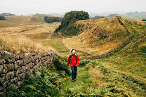 Woman walking Hadrian's Wall in the Northumberland region of the United Kingdom. This section is between Walltown and Housesteads.
