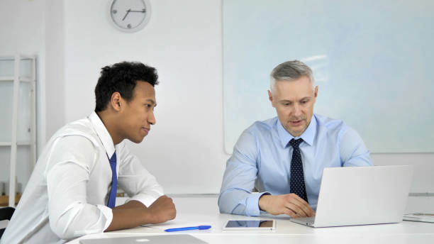 istock Mixed Race Businessmen Discussing Project in Office 1340726764