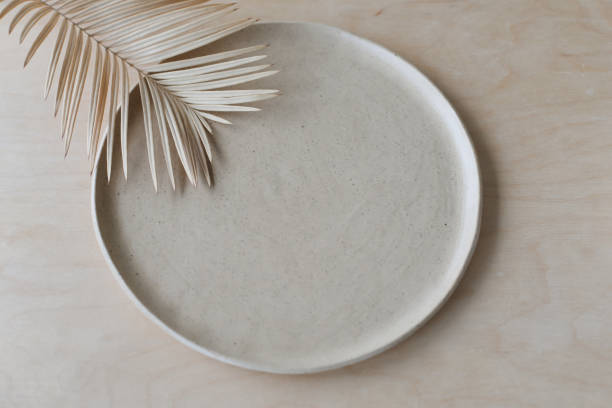 placa de cerámica en una vista de mesa de madera. vajilla y cerámica minimalista hecha a mano - plate ceramics pottery isolated fotografías e imágenes de stock