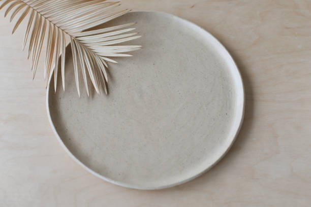 Ceramic plate on a wooden table top view. minimalist handmade ceramic tableware and pottery