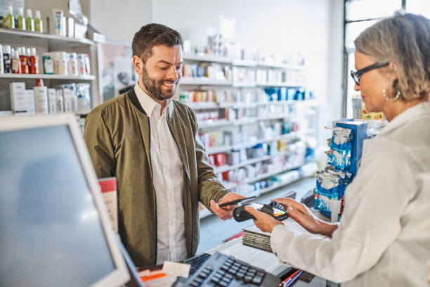 istock Man paying at checkout counter in pharmacy store 1340727397