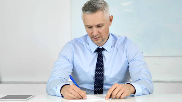 istock Senior Businessman Writing Letter at Work, Paperwork 1340727963
