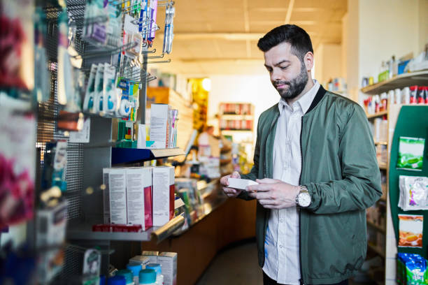 istock Man looking at medicine while shopping at pharmacy 1340728243