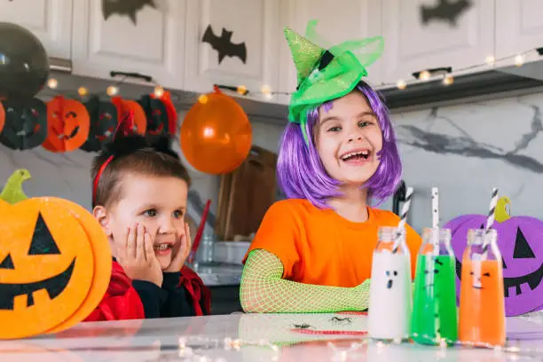 Funny toddler kids in carnival costume on Halloween party with scary drinks. Traditions, holidays, treats concept