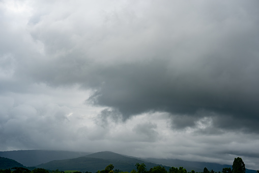 Panorama heavy clouds storm rain on sky over rice field in rural, cloud of rain over hill or mountain of summer season