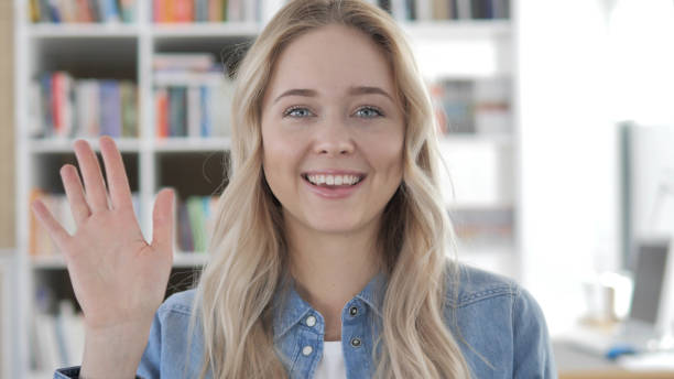 istock Hello by Young Blonde Woman, Waving Hand 1340731126