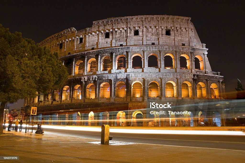 Colosseum in Rome, by night Colosseum in Rome, by night. Ancient building and modern light trail Amphitheater Stock Photo