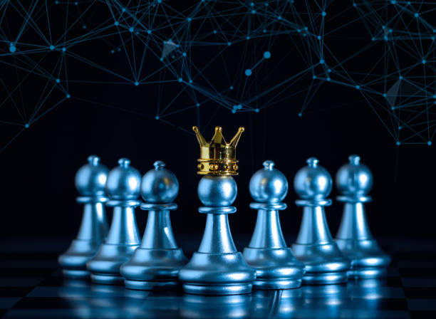istock A silver pawn standing crowned in battle chess game on board with gold chess background. successfully in the competition with technology network background. Management or leadership strategy concept. 1340731811