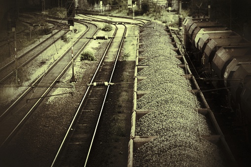 Grungy sepia shot of train filled with gravel.