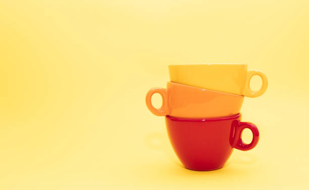 istock Three inspiring vibrant ceramic cups with different colors, red, orange and yellow. Minimalist aesthetic style on bright yellow background. What type of mug are you choosing for your coffee? 1340733319